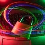 lila, rote und blaue Lichtillustrationen vor einem Laptop mit Vorhängeschloss