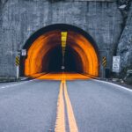 Der EIngang eines Strassentunnels mit englischsprachigen Hinweisschildern