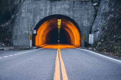 Der EIngang eines Strassentunnels mit englischsprachigen Hinweisschildern